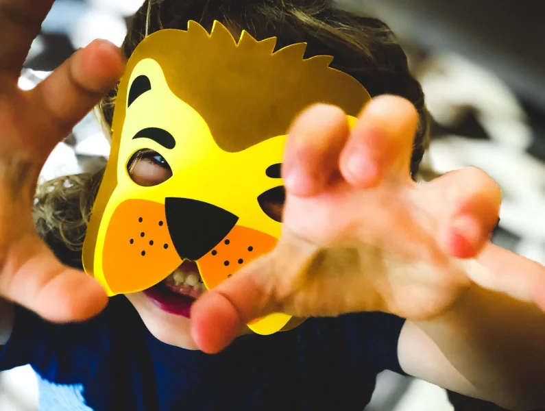 criança com máscara de leão feita de cartão