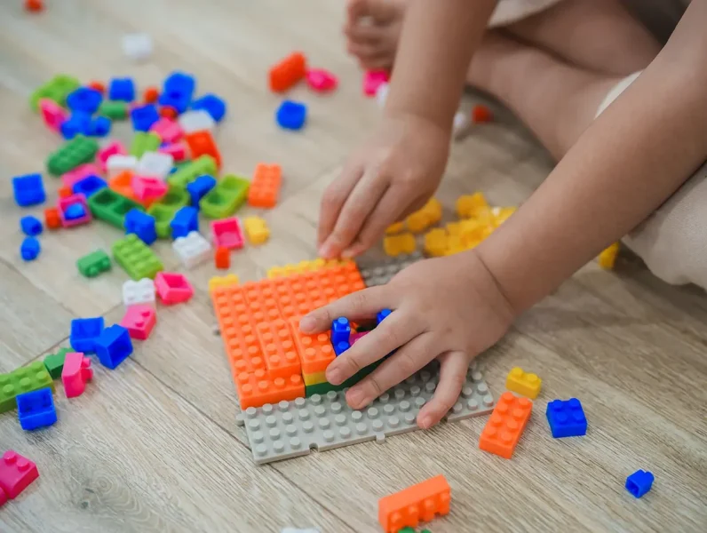 criança a brincar com Lego